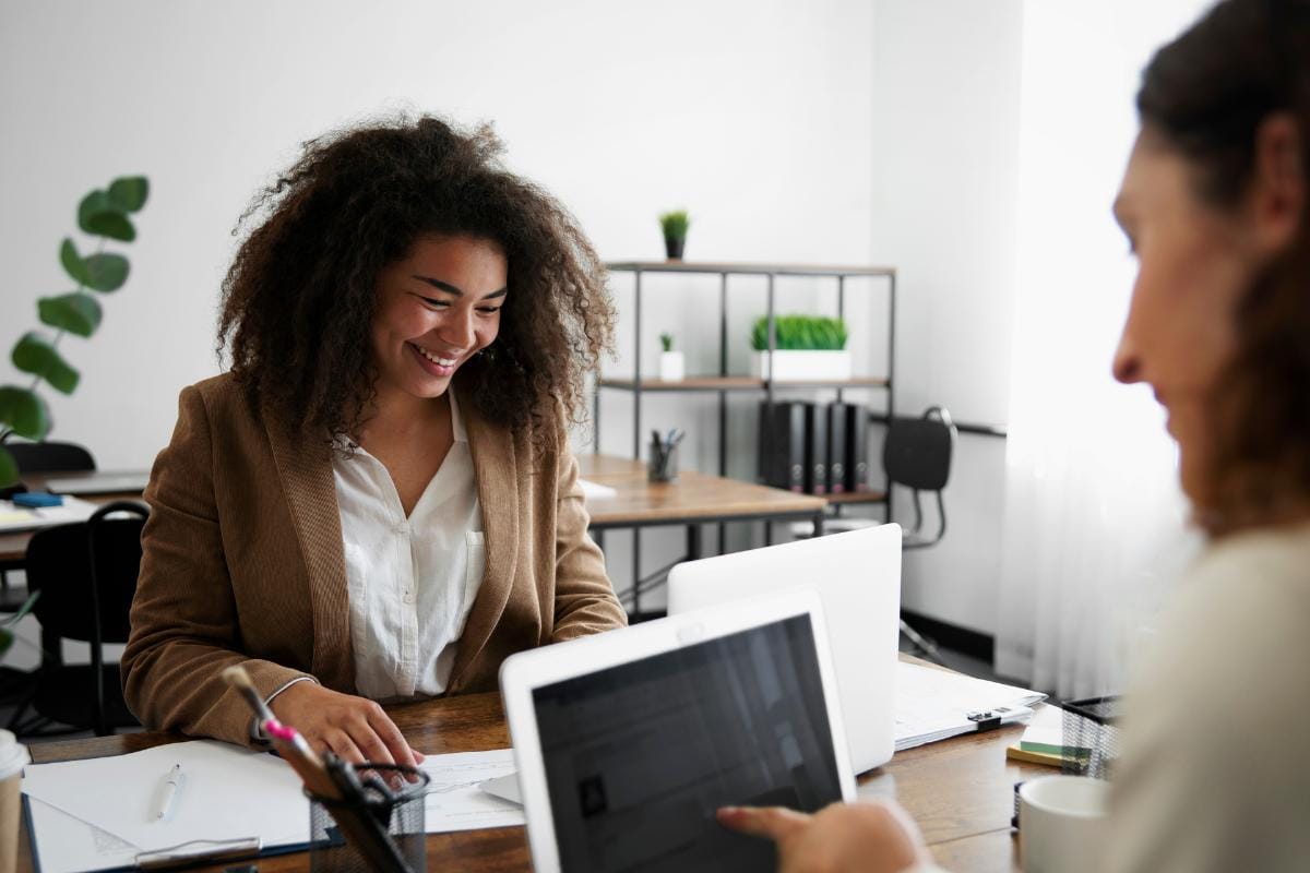 Como captar clientes pelo WhatsApp: 10 estratégias para atrair e converter 2 Atendente sorrindo em frente ao computador enquanto atende um cliente