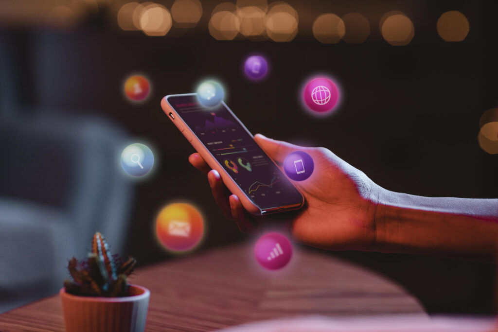 Omnichannel na prática 1 Pessoa utilizando smartphone com dashboard de atendimento digital e ícones representando WhatsApp, e-mail, busca, aplicativos e integração de canais em uma operação omnichannel.